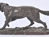 bronze statue of a dog on a rock on a white background