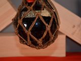 a bottle of wine in a netted bag hanging from the ceiling
