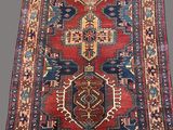 an oriental rug with a red and blue design on a grey background