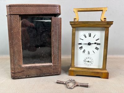 une petite horloge posée à côté d'une petite boîte