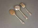 three silver spoons and two silver spoons on a table