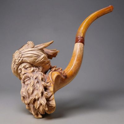une image représentant une pipe sculptée sur laquelle figure une tête d'homme