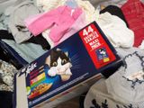 a box of cat food sitting on top of a pile of clothes