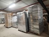 de nombreuses piles de palettes dans un entrepôt où se trouvent de nombreux cartons