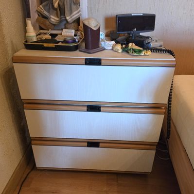 une commode blanche à tiroirs dans une petite pièce
