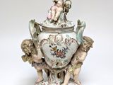 a white vase with a cupid on top of it