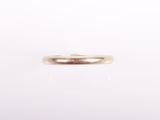 gros plan d'une bague en or sur fond blanc