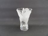 un vase en verre avec une fleur à l'intérieur sur une table