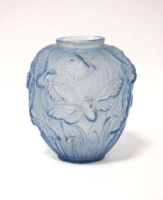 un vase en verre bleu orné d'un motif floral