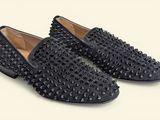 a pair of black spiked shoes on a white background