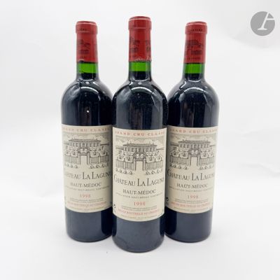 trois bouteilles de vin rouge posées l'une à côté de l'autre sur une surface blanche