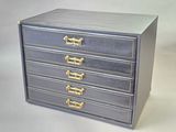 a small blue chest of drawers with gold handles