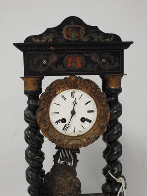 une horloge posée sur un support sur une table