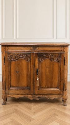 une vieille armoire en bois dans une pièce blanche avec du parquet