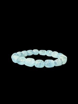 un gros plan d'un bracelet avec des perles bleues sur fond noir