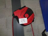 un aspirateur rouge et noir posé par terre à côté d'une chaise bleue