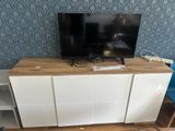 a flat screen tv sitting on top of a wooden entertainment center