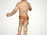 an image of a statue of a child standing on a wooden block