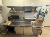 a large stainless steel counter in a kitchen with a lot of boxes