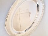 a silver tray with a mirror on it on the wall