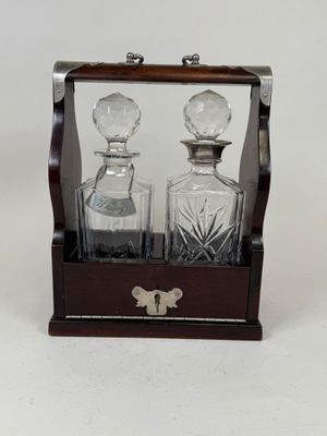 two glass decanters in a wooden case on a white background