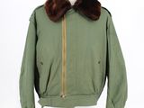 an image of a green jacket with a fur collar on a mannequin stand