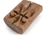 an old wooden block with a carved design on top of it