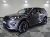 La Land Rover grise est garée dans une grande pièce au sol carrelé en damier.