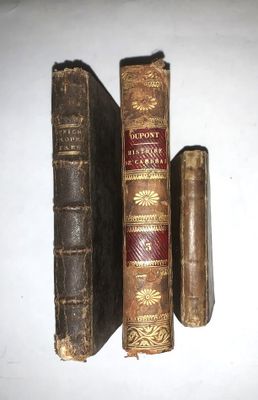 trois vieux livres posés sur une table