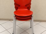 une chaise rouge posée sur un sol carrelé dans une pièce
