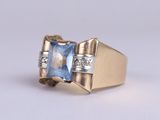 an image of a gold ring with a blue topaz stone and diamonds
