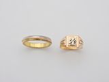 a couple of rings with initials on them sitting next to each other