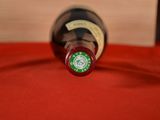 a bottle of wine sitting on a red table