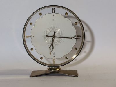 une horloge posée sur un support sur une table