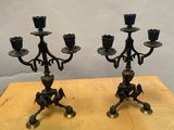 une paire de chandeliers anciens en laiton posés sur une table en bois, sur fond blanc
