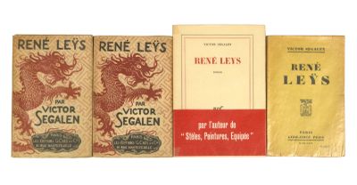 Trois livres sont alignés sur une surface blanche, dont l'un a une couverture rouge.