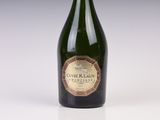 une vieille bouteille de vin posée sur une table blanche