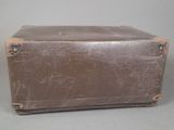 a brown suitcase sitting on a table with a gray background