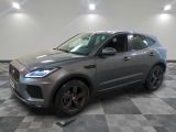 un SUV Jaguar gris garé dans un garage au sol carrelé