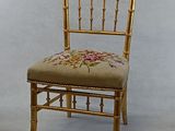 a gold chair with a floral design on the back
