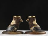 a pair of brown and black animal figurines on wooden bases