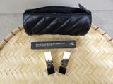 a black purse and two lipsticks on a table