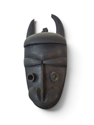 a black mask with horns on it on a wall