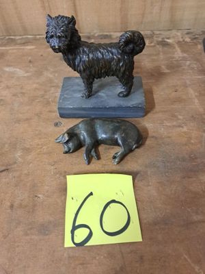 une petite statue représentant un chien et un cochon, posée sur une table