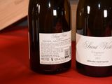 two bottles of wine sitting on a red cloth