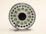 a close up of a fly reel on a white surface