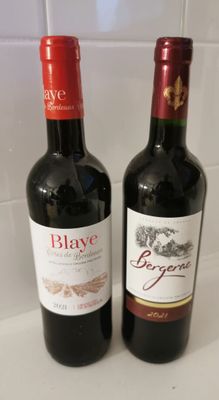 two bottles of wine sitting next to each other on a counter