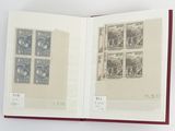 un livre ouvert, orné de timbres, posé sur une surface blanche
