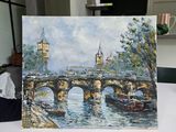 a picture of a painting on a table with a clock in the background