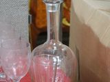 three wine glasses and a decanter sitting on a table